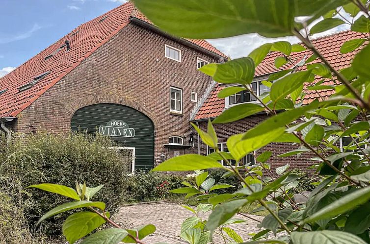 Buitenkant van Unieke 12 pers. Farm Lodge De Muy op Hoeve Vianen in De Cocksdorp, Texel, omgeven door groene natuur.