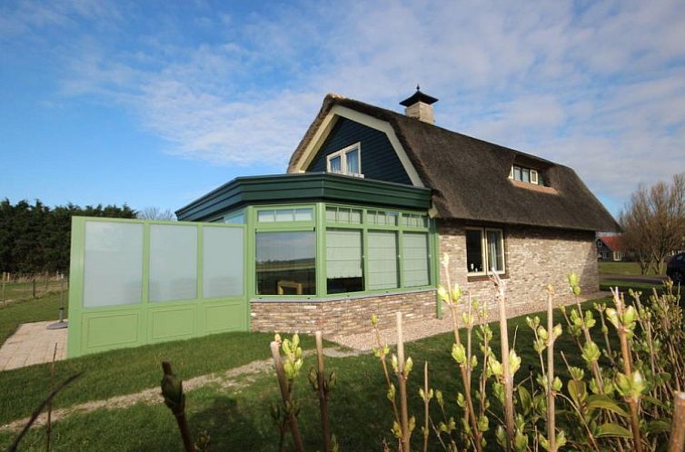 6 pers. luxe villa met serre in De Cocksdorp Texel, charmant vakantiehuis met groene serre en rieten dak.
