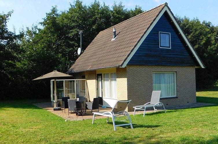 Cottage Krimweg, vacation home in De Cocksdorp Texel with sunny terrace and deck chairs surrounded by nature.