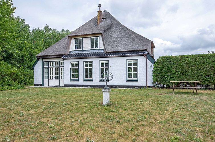 Stolp Nieuw Bornrif vacation home with thatched roof in De Koog, Texel, surrounded by greenery and spacious garden.