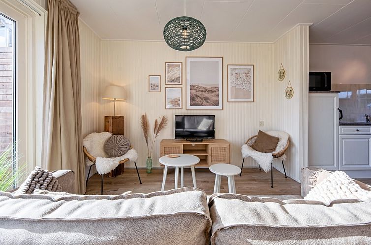 Cozy living room in vacation home Duindroom, De Koog, Texel with comfortable seating area and attractive decorations.