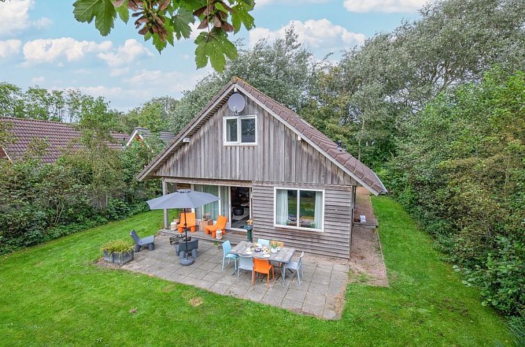 Vakantiepark Het Oude Dijkje - Hulfte, vakantiehuis met terras in De Koog, Texel omgeven door groen.