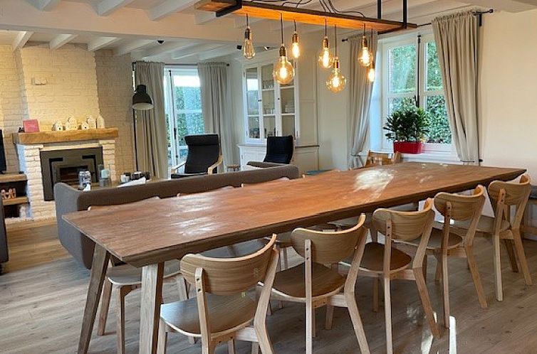 Gemuetliches Esszimmer in Casa Sequoia, einem Ferienhaus in Westvleteren, Westflandern, mit Holztisch und stimmungsvoller Beleuchtung.