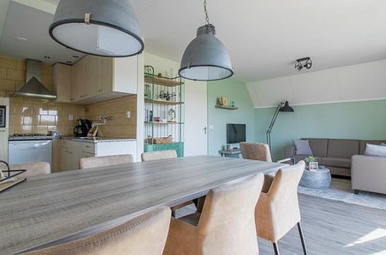 Gezellige eetkamer in Nieuwlanderweg 75 bungalow, De Koog, Texel met moderne inrichting en veel natuurlijk licht.