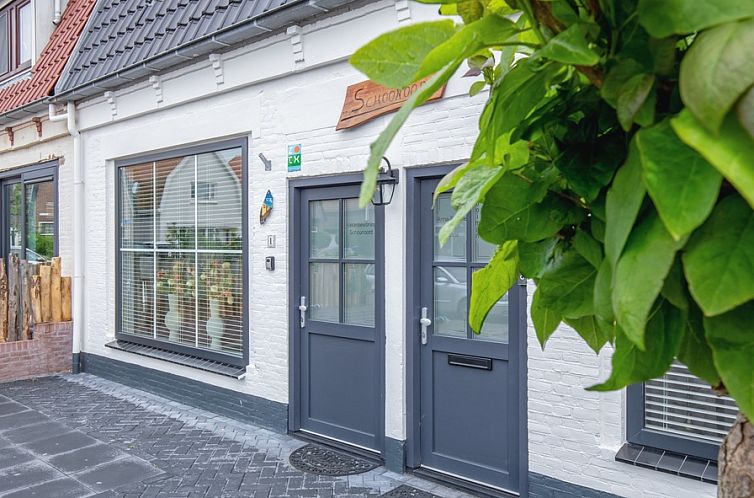 Vooraanzicht van vakantiehuis Schoonoord in Den Burg, Texel met groene omgeving.