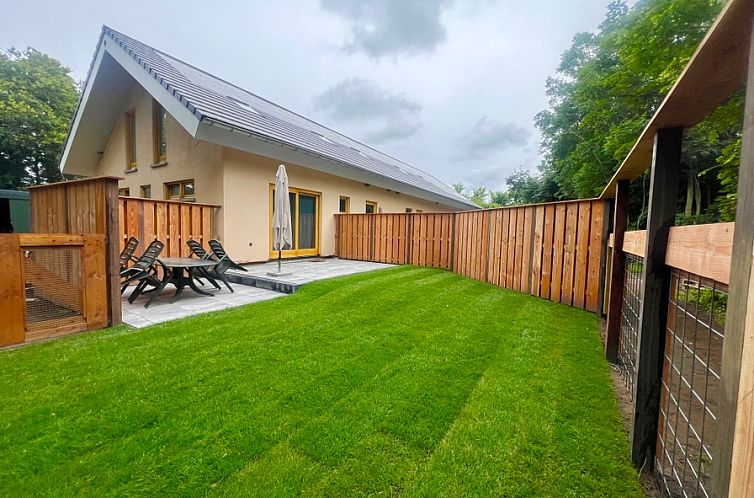 Hoeve Consensus Texel bietet eine geraeumige Terrasse mit Holzzaun in Den Burg, ideal fuer einen entspannten Urlaub auf den Watteninseln.