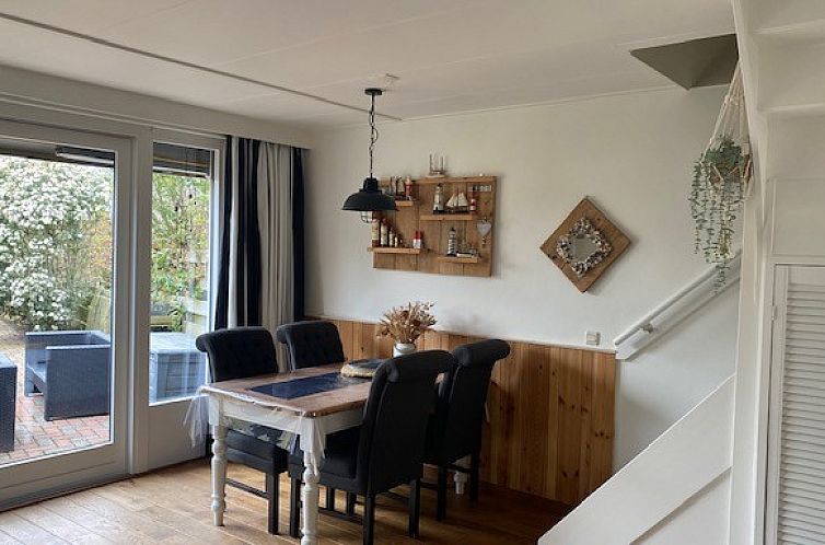 Gezellige eetruimte in vakantiehuis de Jutter, Oost Texel, met uitzicht op zonnige achtertuin.