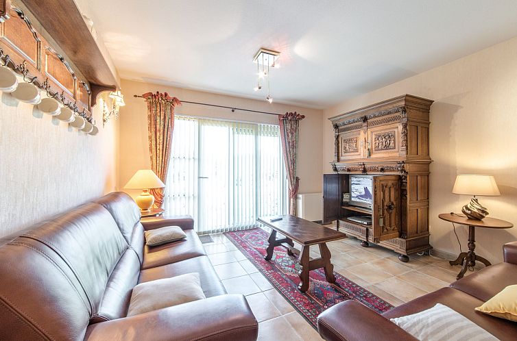 Gezellige woonkamer van Appartement Goldsands II 101 met klassiek meubilair, gelegen in De Haan, West-Vlaanderen, Belgie.
