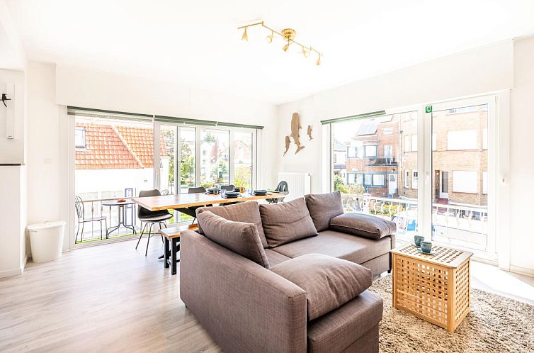 Helles Wohnzimmer des Ferienhauses Argenteuil Two in Koksijde, Westflandern, mit grosser Sitzecke und Blick auf die Umgebung.