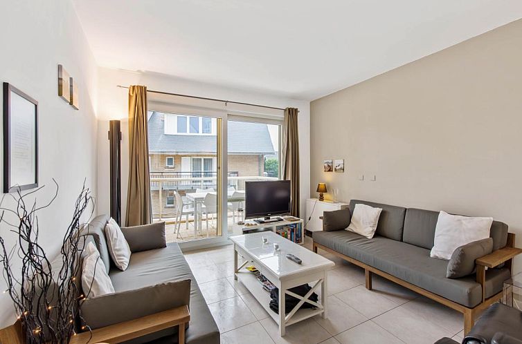 Gemuetliches Wohnzimmer in Klokjesbloem Ferienhaus im Erdgeschoss, Koksijde, Belgien, mit Blick auf die Terrasse und viel Tageslicht.