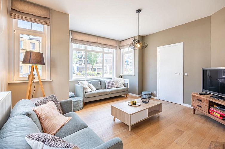 Gemuetliches Wohnzimmer des Ferienhauses Au Coin in Koksijde, Westflandern, mit bequemer Sitzecke und viel Tageslicht.