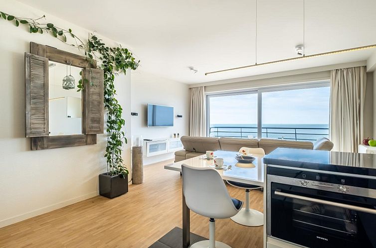 Modernes Wohnzimmer des Ferienhauses Golden Hour in Koksijde, Belgien, mit Meerblick und stilvollem Mobiliar.