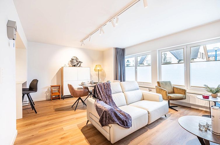 Helles Wohnzimmer des Ferienhauses Bon Plan in Koksijde, Westflandern, mit modernen Moebeln und bequemen Sitzgelegenheiten.