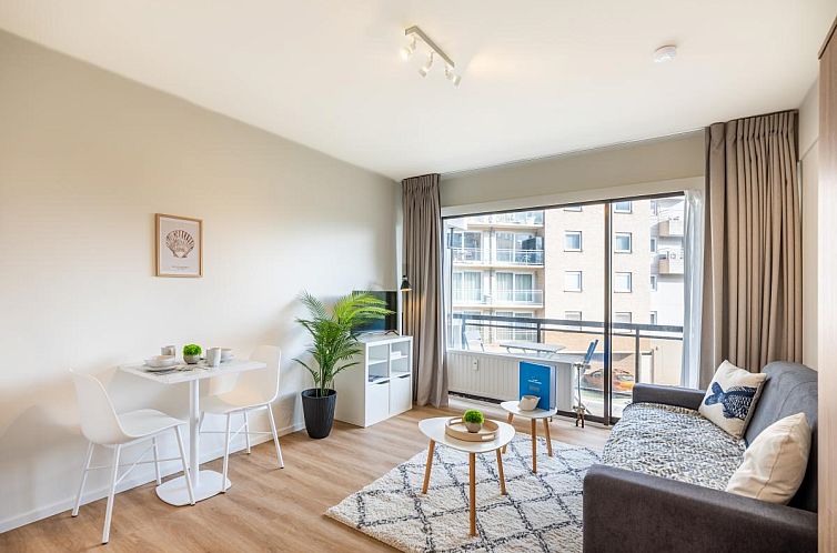 Stilvolles Wohnzimmer des Ferienhauses En Amoureux in Koksijde, Westflandern, mit moderner Einrichtung und Stadtblick.