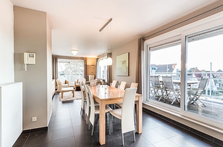 Geraeumiges Esszimmer im Le Penthouse in Koksijde, Westflandern, mit Blick auf die Terrasse und moderner Einrichtung.