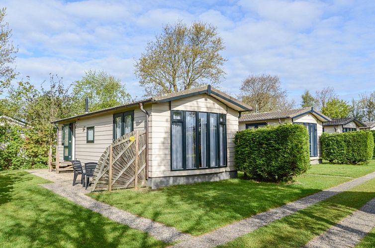 Vacation park De Koorn-aar Type D in De Dennen, Texel, with sunny garden and green surroundings.