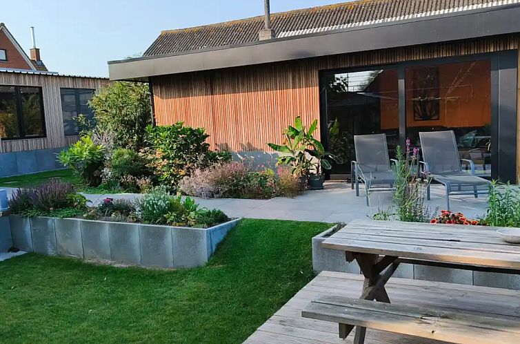 Geniessen Sie den ruhigen Garten und die sonnige Terrasse des Ferienhauses Mote26 in Ingooigem, Westflandern, umgeben von ueppiger Natur.