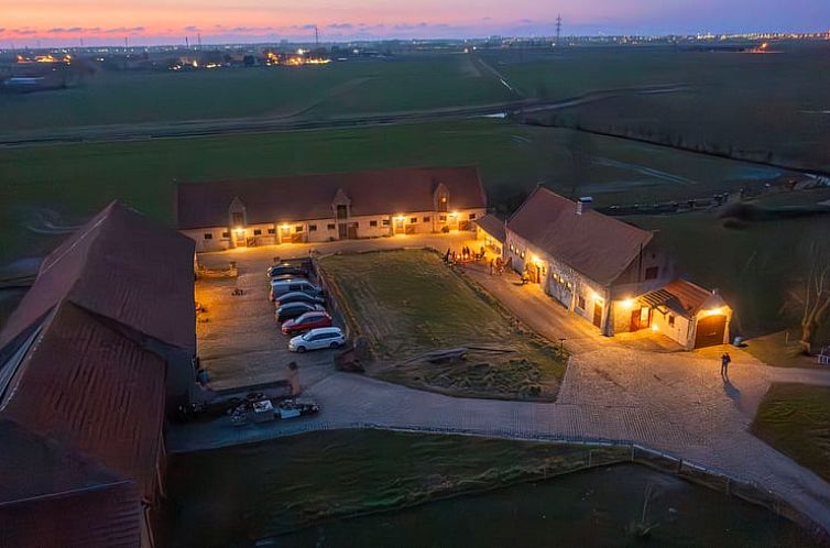 Ferienhaus in Veurne, beleuchtet in der Abenddaemmerung in Westflandern, Belgien, Ferienhaus mit laendlichem Charme und Blick auf Felder.