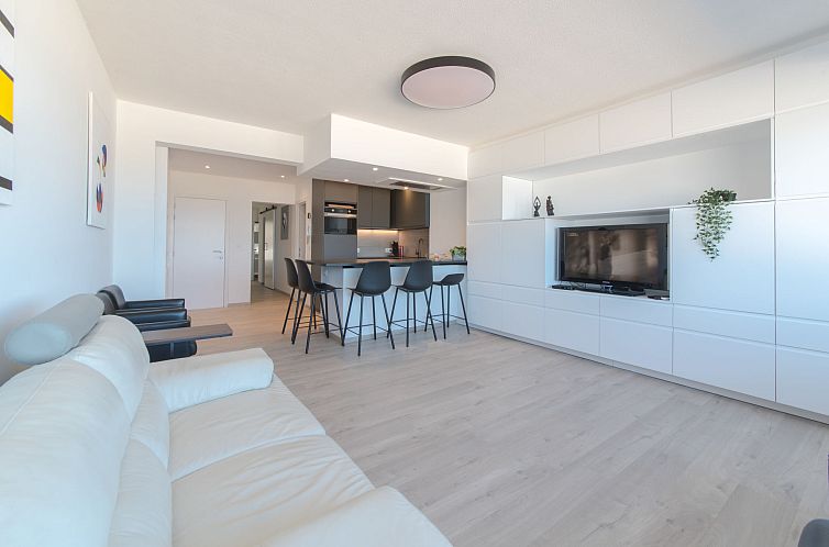 Geraeumiges Wohnzimmer der Ferienwohnung Spirou mit Parkplatz in Ostende, Westflandern. Moderne Einrichtung mit offener Kueche und gemuetlicher Sitzecke.
