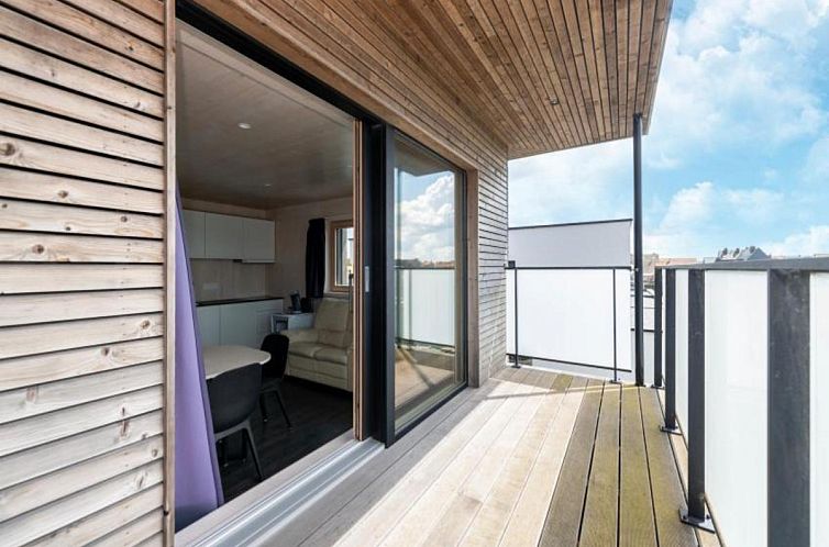 Modernes Aeusseres der Kruiers Eco Lodge, eines Ferienhauses in Middelkerke, Westflandern, Belgien, mit schlichtem Design und gruener Umgebung.