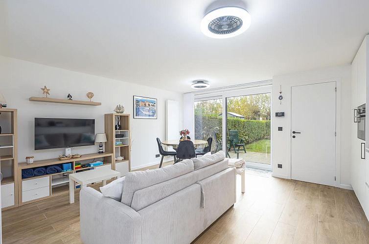 't Zand - 2 + Park. 2 Ferienhaeuser in Westende, Westflandern: modernes Wohnzimmer mit Gartenblick und gemuetlicher Sitzecke.
