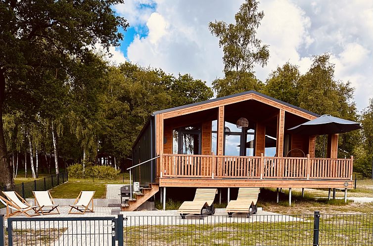 Vakantiehuis Lakehouse Scandi in Wilsum, Nedersaksen, met houten veranda omringd door serene bossen.