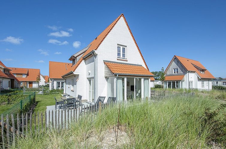 Kindervilla Luxe 6, een charmant vakantiehuis in Bredene aan de Belgische kust, omringd door duinen en een zonnig terras.