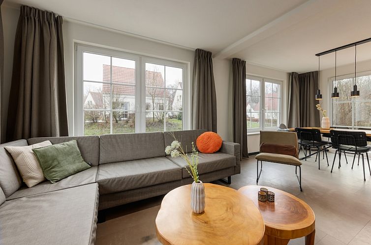 Interior of Koosvilla 4+2 Comfort in Bad Bentheim, Lower Saxony, with comfortable sitting area and large windows.