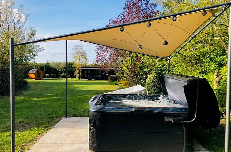 Geniessen Sie den rustikalen Garten mit Jacuzzi im Ferienhaus in Goelenkamp, einem idyllischen Rueckzugsort in Niedersachsen, Deutschland.