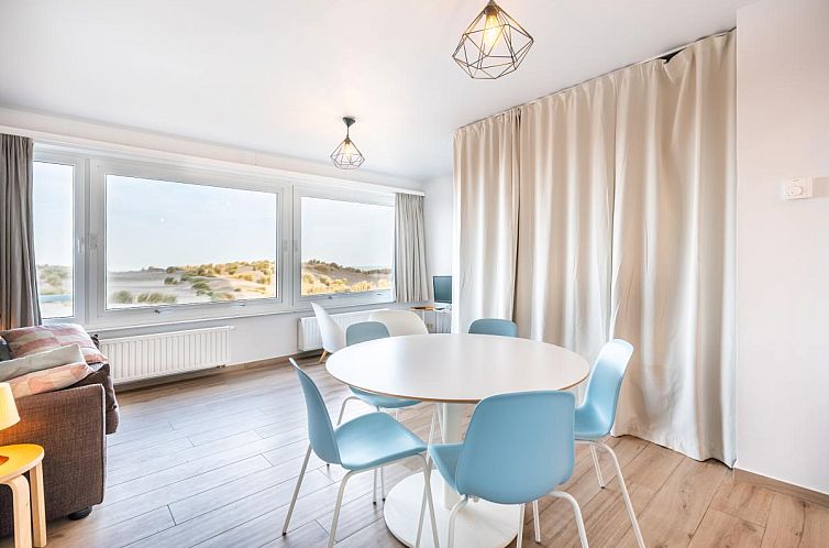 Lichte woonkamer van Manderley tweede vakantiehuis in Oostduinkerke, Belgie, met uitzicht op de duinen en moderne inrichting.