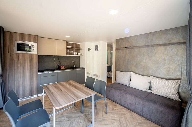 Modernes Interieur des Ferienhauses Lodge in Gent, Ostflandern, mit stilvoller Kueche und gemuetlicher Sitzecke.