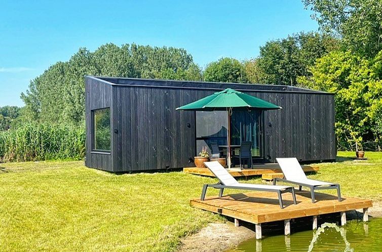 Black Pearl vakantiehuis in Moerzeke, Oost-Vlaanderen, met zonnig terras en uitzicht op vijver.