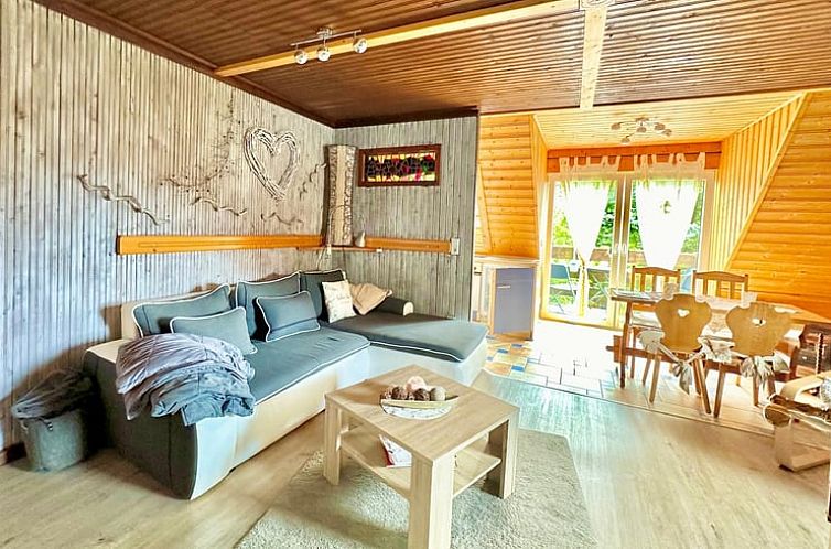 Knusse binnenruimte van Vakantiehuisje in Friedrichsbrunn, Duitsland, met ruime bank en toegang tot het terras.