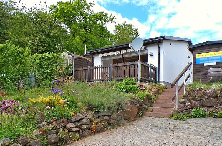 Innenansicht des Ferienhauses in Driedorf in Hessen, Deutschland, mit einer einladenden Sitzecke und einer voll ausgestatteten Kueche.