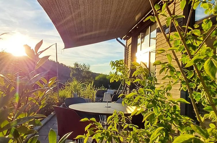 Ontspan op de veranda van Vakantiehuisje in Reichelsheim, Hessen, met uitzicht op een prachtige zonsondergang.