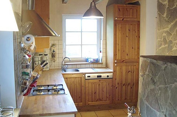 Rustieke keuken van Huisje in Blankenheim, vakantieverblijf in Eifel, Duitsland, met houten kasten en een sfeervolle uitstraling.