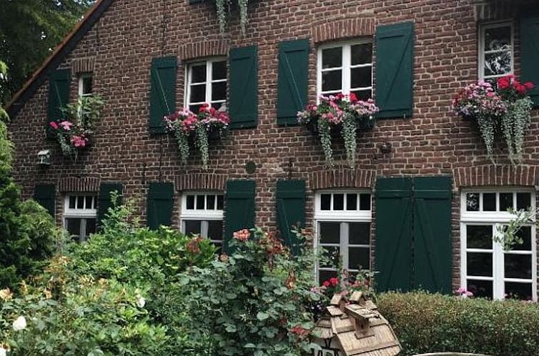 Rustiek Huisje in Grefrath met groene luiken en bloemenpracht, ideaal voor een vakantie in Noordrijn-Westfalen, Duitsland.