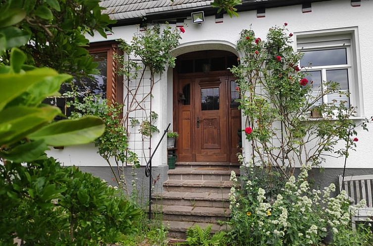 Vakantiehuis in Kirchhundem, Sauerland, Duitsland met uitnodigende entree en kleurrijke bloemen.