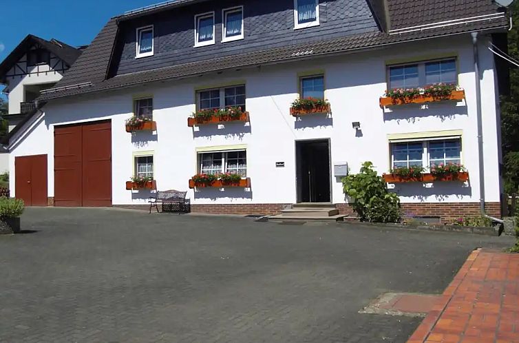 Ferienhaus "Ehemaliges Foersterhaus Wittgenstein" in Bad Laasphe, Sauerland, Deutschland, mit einladender Fassade und Blumenkaesten.