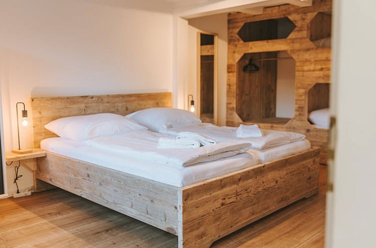 Rustic bedroom in Holiday Home in Winterberg, Germany, offers a warm atmosphere with wooden furniture and luxurious bedding.