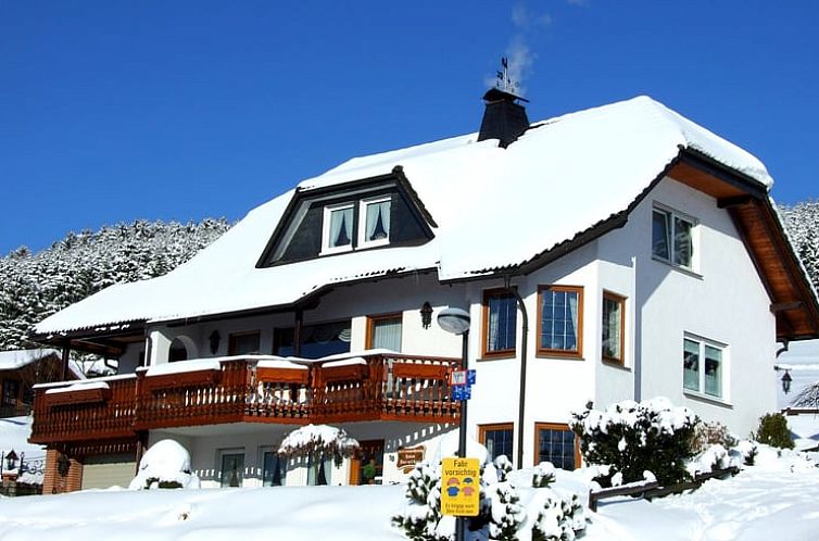 Gezellig Vakantiehuisje in Winterberg, Duitsland: winterse charme met sneeuwbedekt dak en uitnodigend balkon.