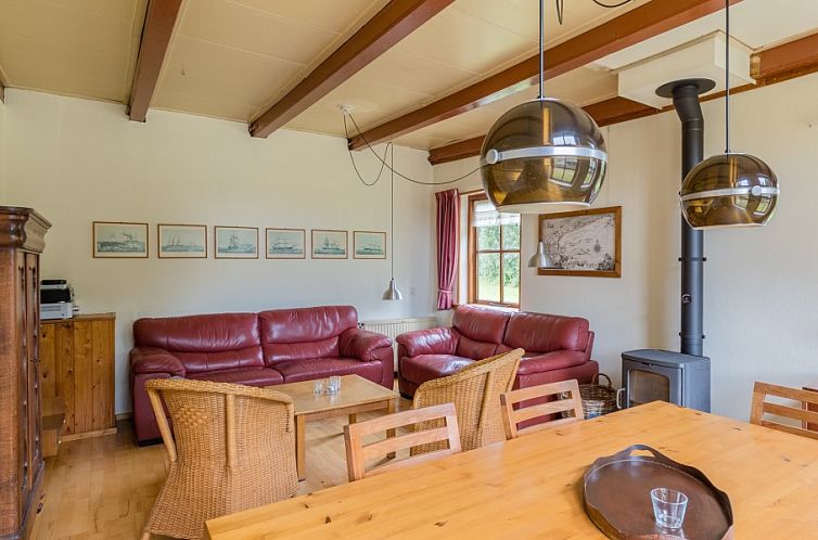 Gemuetliches Wohnzimmer im Ferienhaus Meiblok, Formerum, Terschelling, mit bequemer Sitzecke und Holzofen.