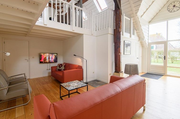Ruime woonkamer van Het Goeie op Terschelling in Lies met hoge plafonds en comfortabele banken.