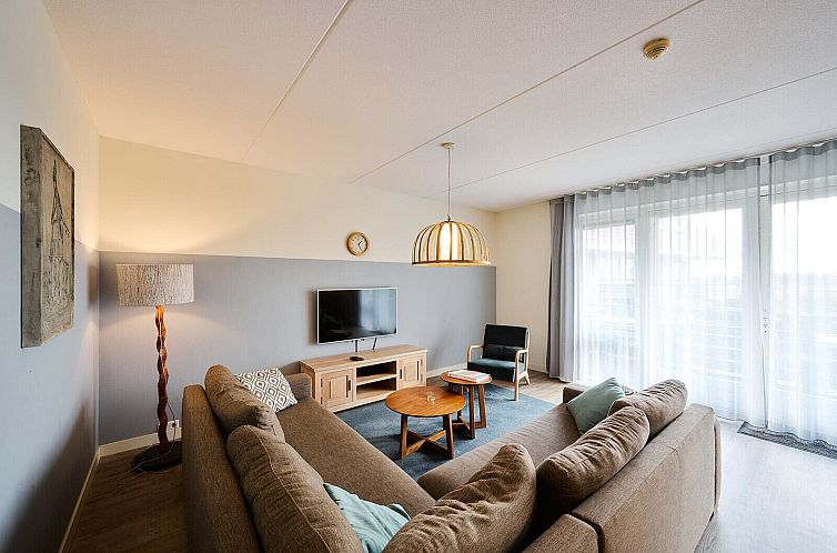 Gezellige woonkamer in Wellness Appartement | 5 Pers in Midsland, Terschelling. Comfortabele zithoek met natuurlijk licht op de Waddeneilanden.