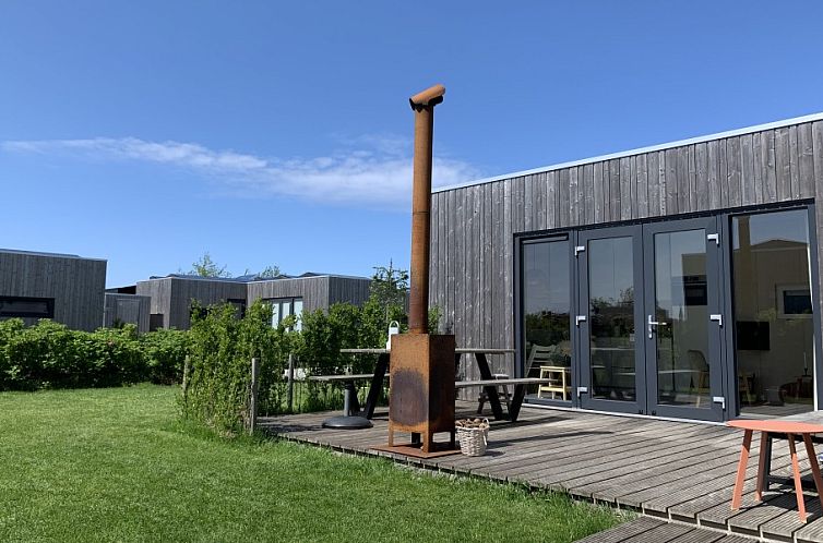 Veranda van vakantiehuis Kleine Walvis in Midsland Noord, Terschelling met uitzicht op groene omgeving.