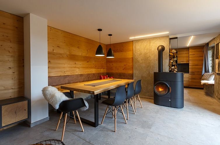 Stilvolle Einrichtung des Ferienhauses in Zella-Mehlis, Deutschland, mit Holzwaenden und einem gemuetlichen Kamin.