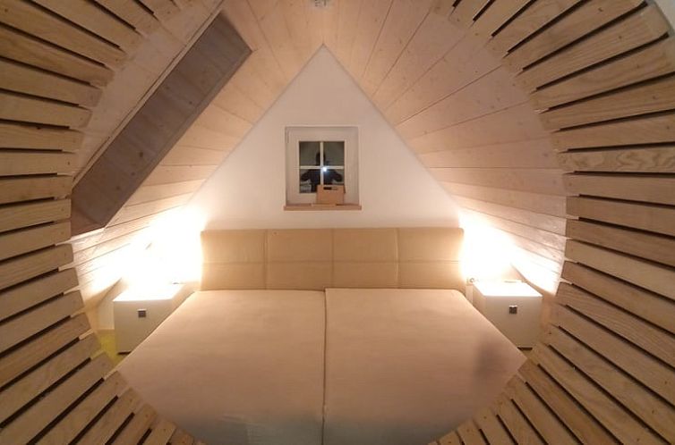 Knusse binnenruimte van Vakantiehuisje in Heinersdorf, Duitsland, met warme houten afwerking en comfortabele bedden.