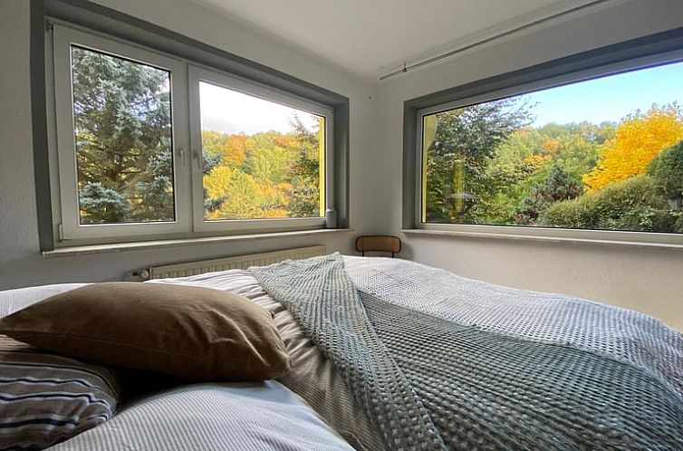 Vacation home in Schmalkalden offers a serene bedroom overlooking the colorful nature of Thuringia, ideal for relaxation.