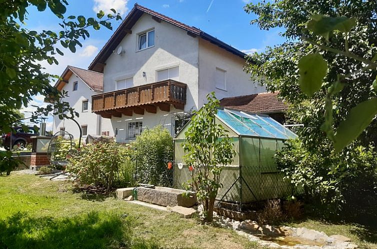 Cozy vacation home in Buchlberg with green surroundings and glass conservatory, ideal for a relaxing stay in Bavaria.