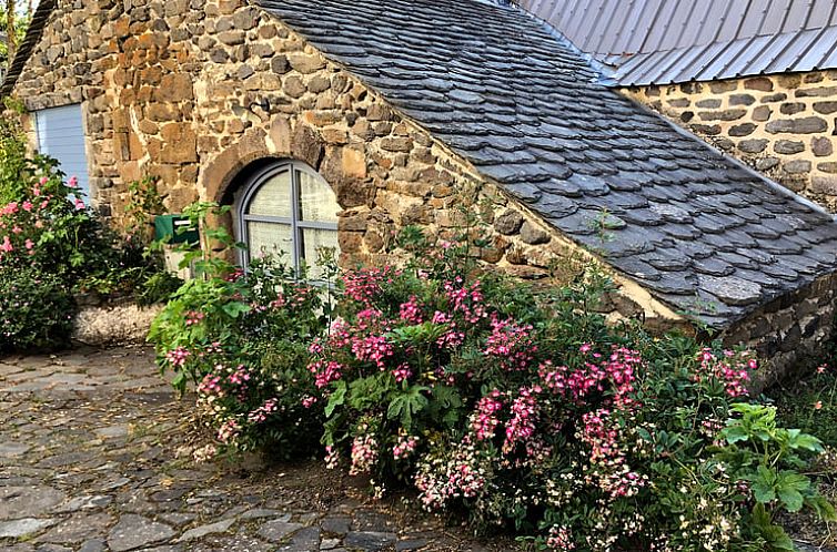 Cozy cottage in Moudeyres, Auvergne, France, with rustic stone facade and colorful flowers for a serene vacation.